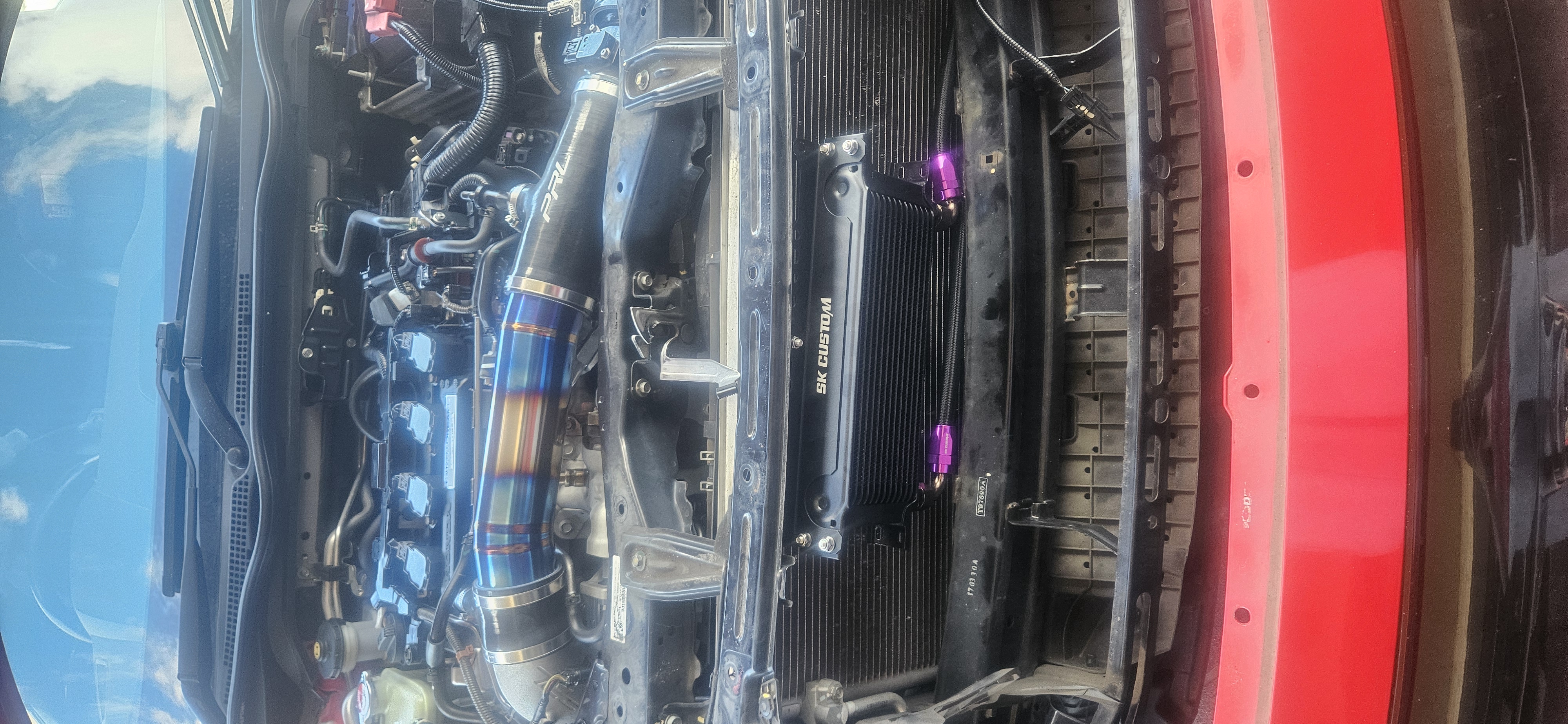 Close-up of engine bay with titanium turbo intake pipe and oil cooler